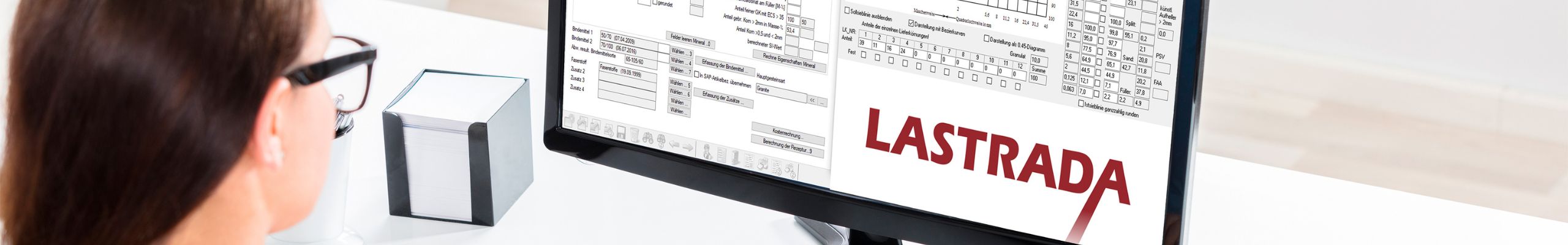 Frau arbeitet am Computer mit geöffneter LASTRADA Software auf dem Bildschirm